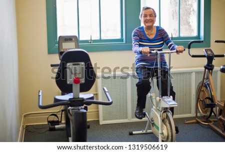 Portrait of a senior woman on an exercise bike at the gym.