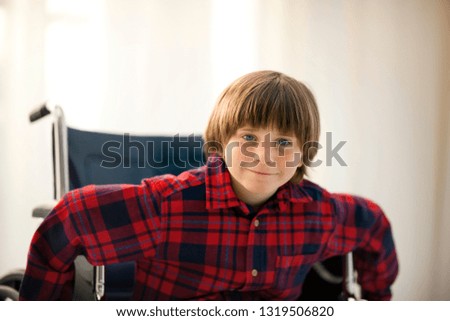 Portrait of a young boy sitting in a wheelchair.