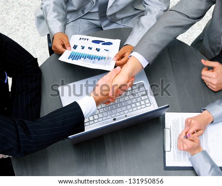 Business people shaking hands, finishing up a meeting Royalty-Free Stock Photo #131950856