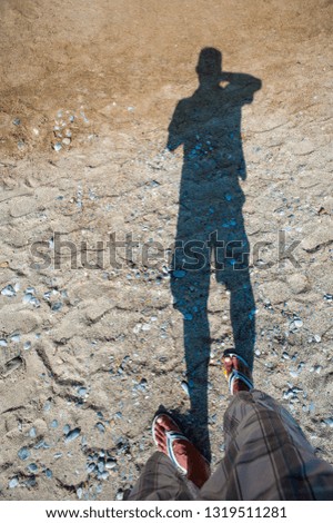 taking pictures of his shadow on the beach