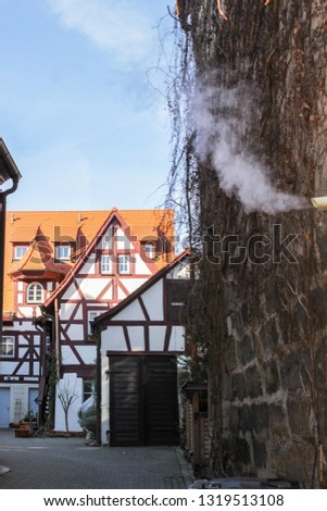   Landscape medieval wall and half-timbered houses. Smoke comes from the chimney. Vertical picture