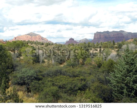 View of thunder clouds rolling over the red rock buttes and hills of Sedona, Arizona.     