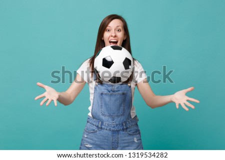 Surprised funny young woman football fan cheer up support favorite team throwing soccer ball isolated on blue turquoise background. People emotions, sport family leisure concept. Mock up copy space