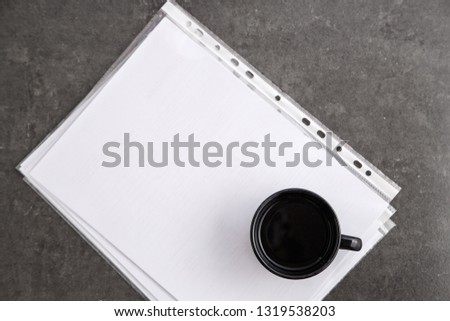 Black coffee Cup on documents on grey marble background. Top view
