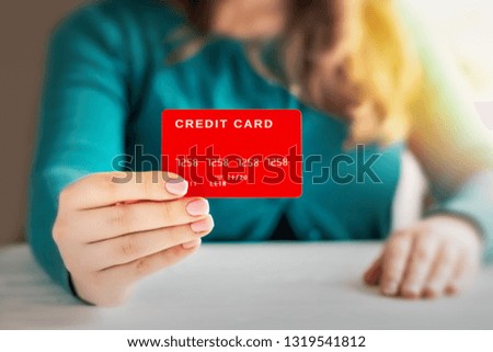 Woman holding a red plastic card in her hand.