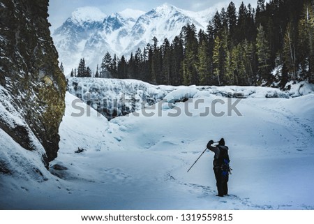 Winter ice trekking in Canada, woman trekker taking photo of Whapta falls