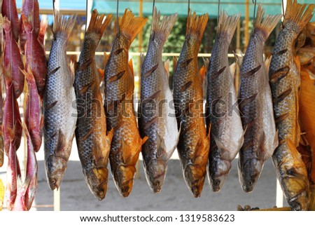 Different types of salted dried fish hanging on ropes on a street market in the south of Ukraine     