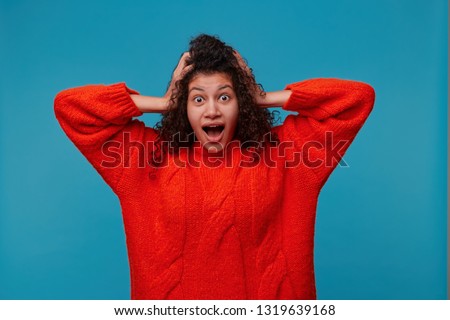 Studio photo of surpised excited woman doesn`t believe her success, keeps hands on head, stares at camera, says omg or wow. Pleasant surprised female looks amazed Royalty-Free Stock Photo #1319639168