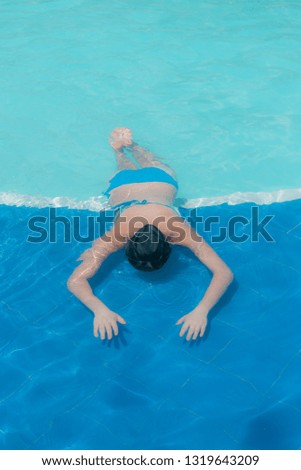 young woman swimming in pool in swimwear