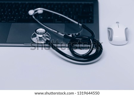 Notebook (Tablet, PC) with medical equipments and a mouse, Medical stethoscope or phonendoscope, Medical device for auscultation, Silhouette on white background.