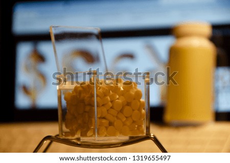 Medicine like tablets and round pills with computer display background with pharmacy and money signs logo