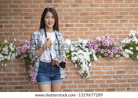 woman with mirrorless camera on brick wall background