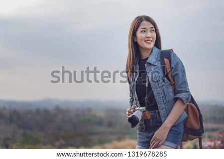 female tourist with backpack and camera in the countryside