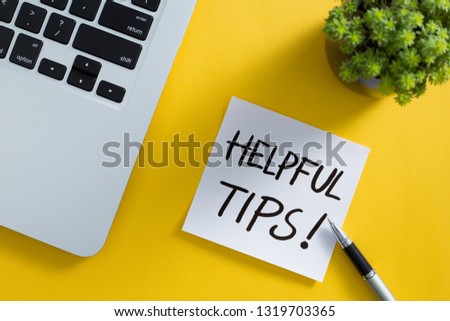 Helpful Tips concept on desktop workspace with office supplies.