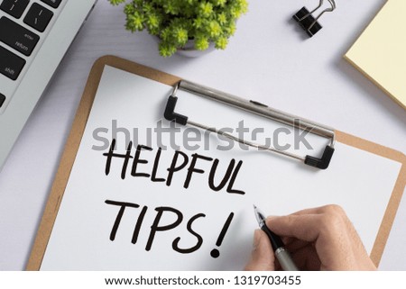 Helpful Tips concept on desktop workspace with office supplies.