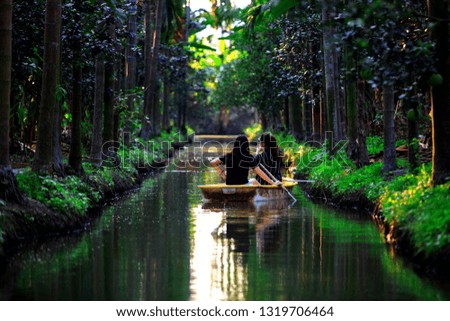Women with boat on groove or ditch  betel garden and fruits is beautiful
