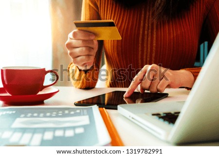 woman using tablet payments online shopping,omni channel,sitting on table,virtual icons graphics interface screen. 