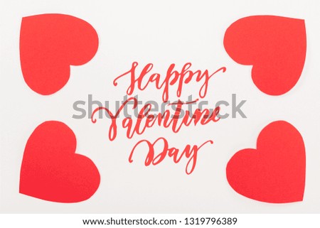 top view of red heart shaped paper cards isolated on white with "Happy valentines day" lettering