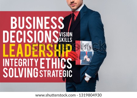 cropped image of businessman holding newspaper isolated on grey with leadership lettering 