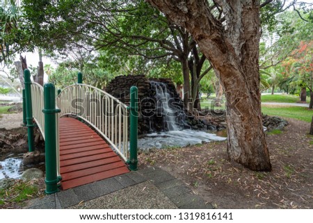 Small footbridge and waterfall in Macintosh island park. Gold Coast, QLD, Australia