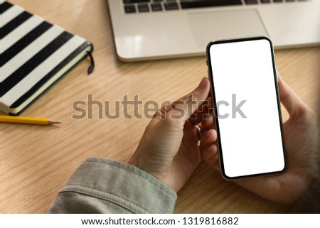 Mockup image man hand holding texting using black mobile,cell phone at desk with copy space,white blank screen for text.concept for contact business,people communication,technology electronic device