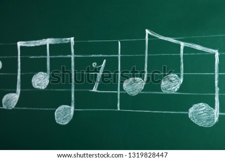 Music staff with notes on green chalkboard