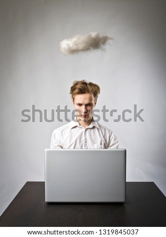 Young man in white with laptop and small cloud. Imagination and virtual cloud concept.