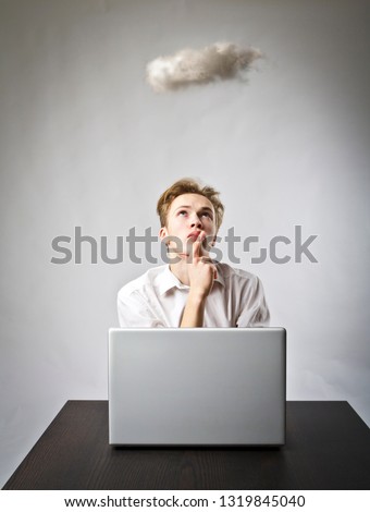 Young man in white with laptop and small cloud. Imagination and virtual cloud concept.
