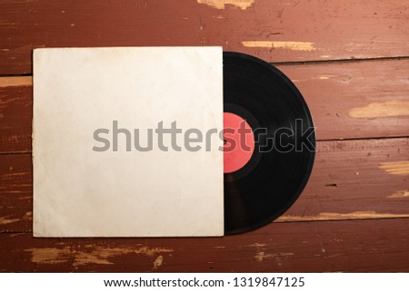 Old vinyl record on old red wooden background. Copy space for your label Royalty-Free Stock Photo #1319847125