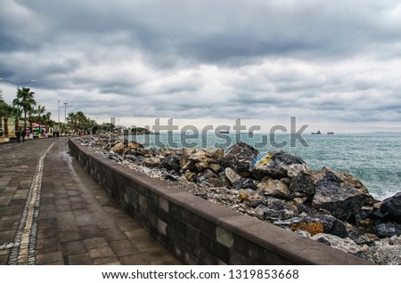 Dramatic landscape on a storm sea in Iskenderun, Turkey with stone pier and costline Royalty-Free Stock Photo #1319853668
