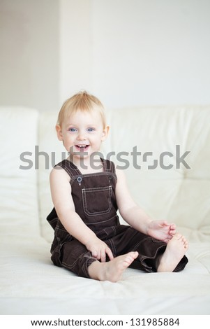 Picture of a baby sitting on a sofa at home