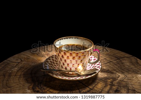 Porcelain cup with saucer and silver spoon, black coffee is served as breakfast  