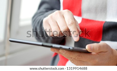 Man hand touching screen on modern digital tablet pc. Close-up image with shallow depth of field. Concept of modern gadgets in use