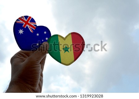 Hand holds a heart Shape Australia and Senegal flag, love between two countries