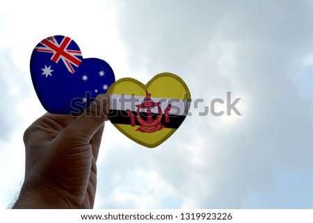 Hand holds a heart Shape Australia and Brunei flag, love between two countries