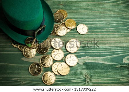 Happy St Patricks Day leprechaun hat with gold coins on vintage green wood background