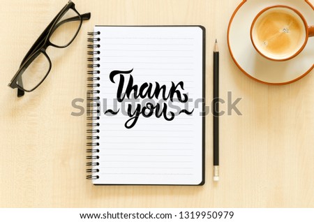 Desktop with notebook, pencil, eyeglasses and coffee cup. Top view flat lay overhead. Employee appreciation day concept. Hand written lettering Thank you Royalty-Free Stock Photo #1319950979