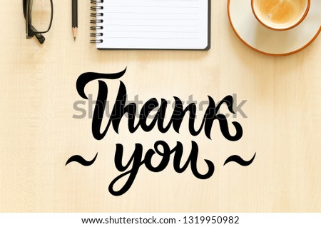 Desktop with notebook, pencil, eyeglasses and coffee cup. Top view flat lay overhead. Employee appreciation day concept. Hand written lettering Thank you Royalty-Free Stock Photo #1319950982