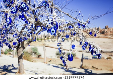The branches of the old tree decorated with the evil eye amulets (Nazars), Goreme, Cappadocia, Turkey.