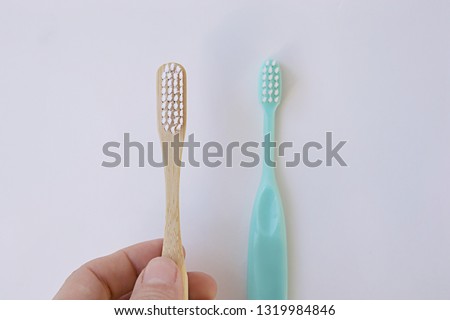 natural bamboo toothbrush versus plastic blue brush