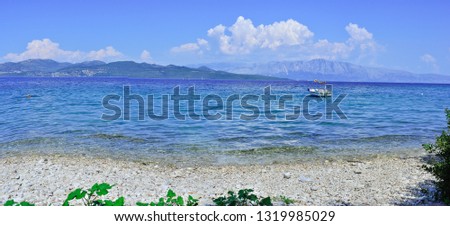 Panorama sea view in Lefkada Greece with small ship and waves on sunset time. Mountains view with clouds from the Mediterranean sea and beach