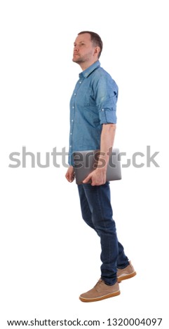 Back view of a walking man with a laptop. Rear view people collection.  backside view of person.  Isolated over white background. Young engineer walks with a laptop looking up.