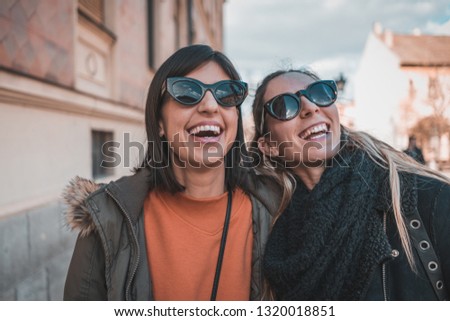 Two urban woman friends in city having fun. Two  hipster females in town walking and talking Royalty-Free Stock Photo #1320018851