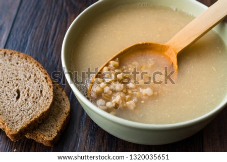 Wheat Soup with Chicken Broth Bouillon on Dark Wooden Surface.
