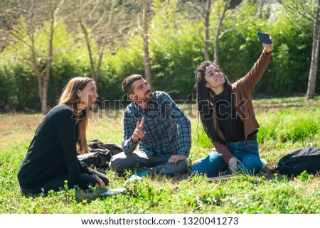 Happy group of students at the park talking and taking a picture. Studying together at university campus. University friendship.