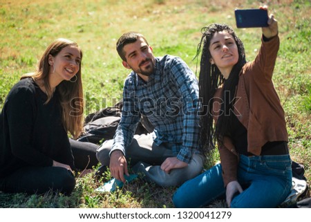 Happy group of students at the park talking and taking a picture. Studying together at university campus. University friendship.