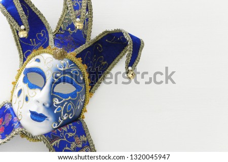 blue with gold elegant traditional venetian mask over white wooden background