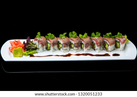 asian oriental food sushi and rolls with different fillings on a black background with reflection sushi philadelphia