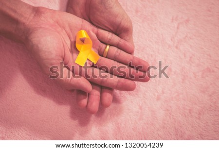 Cancer awareness hand ribbon top view, vintage picture style donate healthcare concept.