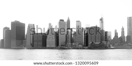 New York Financial District and the Lower Manhattan at dawn viewed from the Brooklyn Bridge Park. High key black and white image.